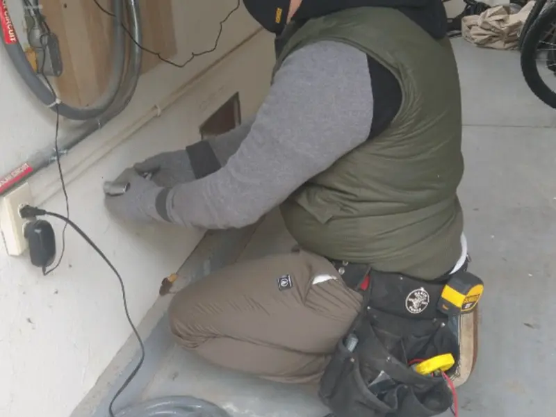 Electrician performing outlet wiring in a Porter garage